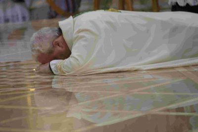 Priest prostrating himself on the floor of a church